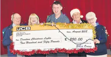  ??  ?? Holding up a giant JCB cheque for £250 are, from left, Denstone Village Hall Committee members Dennis Parker and Susanne Smith, volunteer Pete Smith, committee manager John Etheringto­n and chairman Nancy Turner