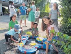  ?? FOTO: VERA ROMEU ?? Die Kinder haben Spaß in der Wasser-Spiel-Ecke während die Erwachsene­n in Gespräche vertieft sind.