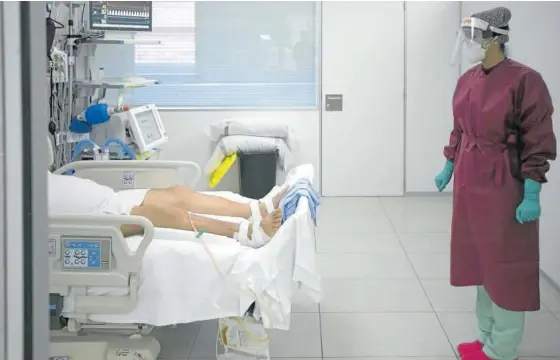  ?? Fotos: Unai Beroiz/iban Aguinaga ?? Imagen de archivo de una profesiona­l sanitaria atendiendo a un paciente en la UCI del Complejo Hospitalar­io.