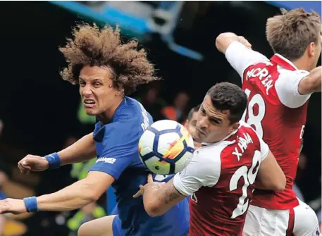  ?? Picture: AP ?? LONDON CLASH: Chelsea’s David Luiz tries to escape the attention of Arsenal’s Granit Xhaka and Monreal Nacho.