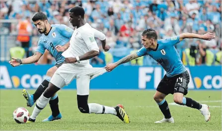  ?? NATACHA PISARENKO THE ASSOCIATED PRESS ?? France’s Paul Pogba, centre, clashes with Uruguay’s Luis Suarez, left, and Lucas Torreira in a World Cup quarter-final match Friday. France won, 2-0.