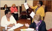  ?? / Doug Walker ?? Housing consultant Cheryl Molock holds up leasing reports for the Northwest Georgia Housing Authority to examine. Executive Director Sandra Hudson (left) and authority Chairman Lee Hight review documents in their board packet.