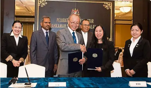  ??  ?? Arifin (third from left) exchanging the Memorandum of Agreement with Prof Hon. Looking on are (from left) Ooi, Nantha, Md Raus and Lim.