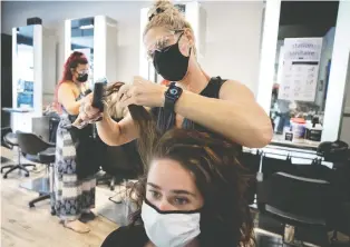  ?? ALLEN MCINNIS ?? Hairdresse­r Isabelle Lachance at Salon Oblic in Ahuntsic is back at work cutting hair. Hair salons across Montreal are subject to new protocols, including cleaning, wearing masks and installing barriers.