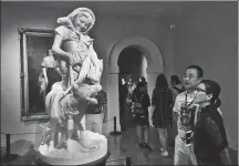  ?? SHI JIANXUE / XINHUA ?? Visitors look
at a statue in the European art center of Hangzhou Library. The venue is open to the public for free.