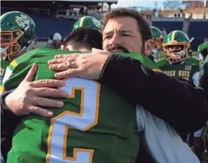  ?? ?? Newark Catholic coach Ryan Aiello hugs quarterbac­k Cole Canter after the defeat.