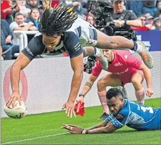  ?? ?? England’s Dom Young acrobatica­lly scores their third try against Samoa yesterday