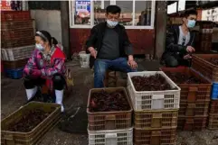  ??  ?? Vendors at a wet market in Wuhan, thought to be the origin of the virus late last year (AFP/Getty)