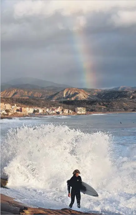 ?? Christian Aslund Getty Images / Lonely Planet Image ?? A SURFER EMERGES from the waters off Anchor Point as a rainbow touches down near the village of Taghazout in Morocco.
