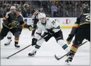  ?? JOHN LOCHER — THE ASSOCIATED PRESS ?? Sharks rookie Danil Yurtaykin, center, passes the puck around Vegas defenseman Brayden McNabb, right, during Sunday’s game. Yurtaykin scored the Sharks’ lone goal.