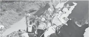  ??  ?? TRAGIK: Pasukan penyelamat berusaha mengeluark­an mangsa dari dalam van yang terjatuh dalam runtuhan tersebut.
