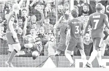  ?? — AFP photo ?? The ball goes into the net after a clearance hit Chelsea’s defender Marcos Alonso (seond right) in the head as Huddersfie­ld Town’s Danish goalkeeper Jonas Lossl (second left) dives for Chelsea’s first goal to equalise 1-1 during the English Premier...