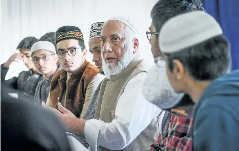  ?? JEFF MCINTOSH/THE CANADIAN PRESS ?? Calgary Imam Syed Soharwardy, centre, founder of Muslims Against Terrorism and the Islamic Supreme Council of Canada, speaks to Muslim youth about anti-radicaliza­tion strategies at a mosque Calgary, on Oct. 6.