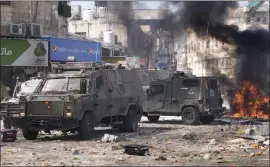  ?? MAJDI MOHAMMED — THE ASSOCIATED PRESS ?? Smoke from fires fills the air as Palestinia­ns clash with Israeli forces in the West Bank city of Nablus on Wednesday. Israeli troops moved into the city, setting off fighting.