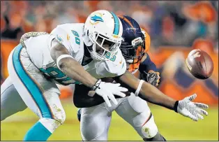  ?? JOE MAHONEY/THE ASSOCIATED PRESS ?? Dolphins tight end Dion Sims (80) can’t hold onto the ball as Denver safety T. J. Ward hits him during the second half of Sunday’s game.