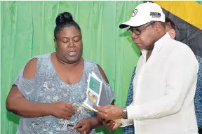 ??  ?? Minister of Tourism Edmund Bartlett (right) receives a marketing plan laid out by vendors at the Harbour Street Craft Market in Montego Bay, St James, from president of the Craft Traders and Producers Associatio­n, Melody Haughton Adams, during his tour of the facility last week. Partly hidden is chairman of the Tourism Product Developmen­t Company, Ian Dear.