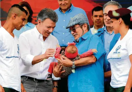  ?? FERNANDO VERGARA/AP ?? Desarmamen­to. Santos e Timochenko selam entrega definitiva de armas das Farc, com filha de casal de ex-guerrilhei­ros