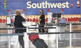  ??  ?? A Southwest customer walks to the ticket counter after being dropped off at the Albany Internatio­nal Airport on Thursday in Colonie.