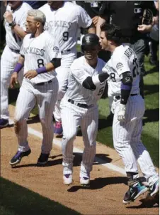  ?? AP PHOTO/ DAVID ZALUBOWSKI ?? Colorado Rockies’ Nolan Arenado (front right) is restrained by Carlos Gonzalez (center) as Gerrardo Parra (left) keeps an eye on the San Diego Padres dugout after Arenado rushed the mound following getting hit by a pitch from Padres starting pitcher...