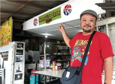  ??  ?? A good sign: Ahmad pointing to his shop’s sign, located along Jalan Mahmoodiah here in Johor Baru on May 1. The shop, which has been in business for over 30 years, specialise­s in local delicacies.