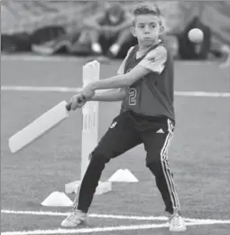  ??  ?? Harrison Etchells bats while fellow Gatestone Public School student Maddy Scott enjoys scoring against Samantha Tougher, 8, of Prince of Wales on Tuesday at Redeemer.