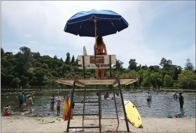  ?? JANE TYSKA — STAFF ARCHIVES ?? A lifeguard watches over swimmers at Lake Temescal in Oakland last month. According to a new study, if greenhouse gas emissions continue at the current rate, the number of days a year when the heat index exceeds 100degrees Fahrenheit will increase.