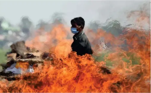  ?? Agence France-presse ?? A worker walks past a funeral pyre at a cremation ground in Allahabad on Saturday.