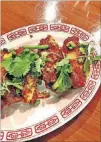  ??  ?? Chongqing chicken wings are garnished with cilantro and scallions.