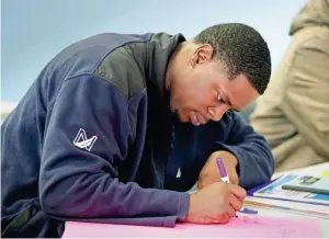  ?? RICK WOOD / MILWAUKEE JOURNAL SENTINEL ?? Shaquille Bridges, 23, works on a word board describing his qualities. He feels he is getting a “second chance” to turn his life around through Pro Trade Job Developmen­t, which offers a 10-week program aimed at teaching painting and carpentry as well...