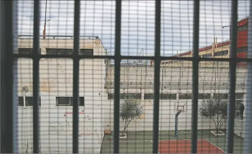  ??  ?? An inmate (far right) stands at the yard of his school in Avlona prison.