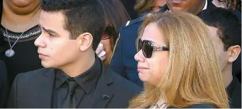  ??  ?? Les policiers accompagna­ient hier le cercueil de Rafael Ramos, recouvert du drapeau du Départemen­t de police de la Ville de New York. Le fils et l’épouse de l’agent tué, Justin Ramos et Maritza Ramos.