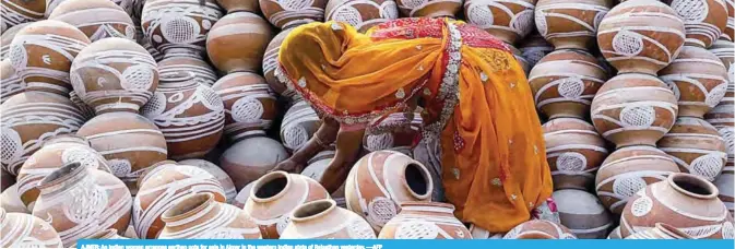  ??  ?? AJMER: An Indian woman arranges earthen pots for sale in Ajmer in the western Indian state of Rajasthan yesterday. —AFP
