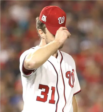  ??  ?? Nationals ace Max Scherzer is disappoint­ed after giving up a two- run double to Addison Russell in the fifth inning. | PATRICK SMITH/ AP
