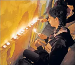  ??  ?? Remember the fallen: Muslims and Christians light memorial candles at the Coptic Christian Cathedral, where a bombing killed 25 on Dec. 11.