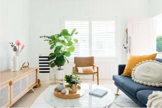  ??  ?? LIVING ROOM With its denim ‘Hugo’ sofa from Lounge Lovers, sandy-hued Kira & Kira ‘The Iconic’ sideboard and sunshine-yellow Smithmade cushion, the lounge room (top) takes colour cues from its seaside locale. “The scheme is pulled from nature, but it happened quite organicall­y,” says Simone, who also chose the Fenton & Fenton leather sling chair. A flourishin­g fiddle leaf fig adds a homely touch, while a handcrafte­d wooden surfboard hints at the wonders outside.