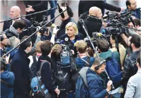  ?? — AFP ?? PARIS: French far-right Front National (FN) party president, member of European Parliament and candidate for France’s 2017 presidenti­al election, Marine Le Pen (C) addresses journalist­s during a visit at a horse fair.