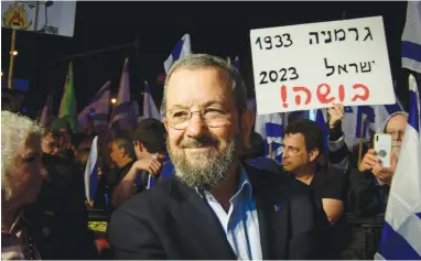  ?? (Avshalom Sassoni/Flash90) ?? FORMER PRIME minister Ehud Barak attends a protest against the government’s planned judicial overhaul, in Tel Aviv, earlier this year. The sign behind him reads: ‘Germany 1933, Israel 2023, disgrace!’