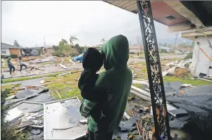  ?? AP PHOTO ?? Eshon Trosclair holds her son Camron Chapital after a tornado tore through home while they were inside Tuesday, Feb. 7, 2017 in the eastern part of New Orleans.