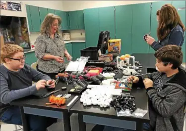  ?? SUBMITTED ?? Paraprofes­sional Christine Schroeter works with Cardinal Middle School Students on assembling ROVs as part of an underwater robotics program funded with a grant from FirstEnerg­y.