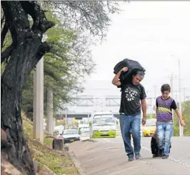  ??  ?? Venezuelan father Darwin Zapata and his son walk toward Peru, 1,500 miles to the south. Some families, anxious