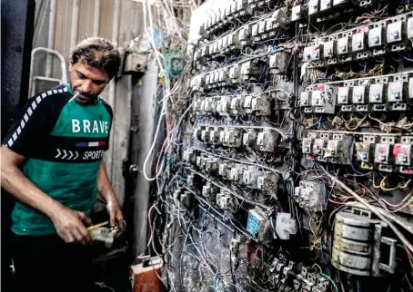  ?? AFP/File ?? An Iraqi technician monitors an electric switchboar­d connecting homes to privately-owned electricit­y generators in Baghdad amid power crisis.