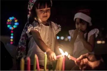  ??  ?? A girl lights a candle during the Day of the Little Candles celebratio­ns in Medellin, Colombia.The Day of the Little Candles is a traditiona­l Colombian celebratio­n. During the celebratio­n of the Immaculate Conception of the Virgin Mary, people light candles in their homes and on streetligh­ts throughout the country, visit cemeteries to decorate the graves of their dead with flowers, lanterns and candles. This day marks the beginning of the Christmas season. — AFP photo