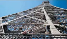  ?? FOTO: THOMAS SAMSON/DPA ?? Geschafft: Ein Besucher genießt die Aussicht vom Eiffelturm, nachdem er die Treppen zum zweiten Stock erklommen hat.