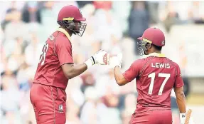  ?? FILE ?? West Indies captain Jason Holder (left) and Evin Lewis tap gloves during the recent fourth one-day internatio­nal against England at the Oval in London.