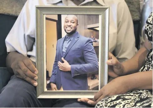  ?? Pictures: Tracy Lee Stark ?? HAPPY TIMES. Joseph and Angela Mhere, the parents of Simba Mhere, hold up a photograph of their son, who was killed in a car accident. His mother and father spoke toat their home in Honeydew.