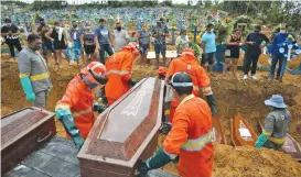  ??  ?? Gravedigge­rs carry a coffin during a collective burial of people who have died due to COVID-19, at the Parque Tarumã cemetery in Manaus.