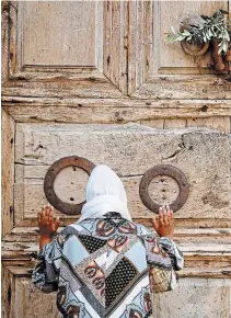  ?? ARIEL SCHALIT THE ASSOCIATED PRESS ?? A woman prays in front of the closed Church of the Holy Sepulchre, a place where Christians believe Jesus Christ was buried, in Jerusalem's Old City on Sunday.