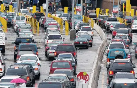  ?? Photograph­s by David Maung Associated Press ?? TRAFFIC LINES stretch into the distance at a border crossing from Tijuana into San Diego. The SENTRI lines, or Secure Electronic Network for Travelers Rapid Inspection system, was supposed to speed entry, but it hasn’t.