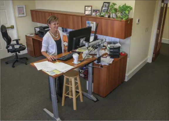  ?? DIGITAL FIRST MEDIA FILE PHOTO ?? Rose Walters makes use of her new standing desk in her office at the Pottstown Health Foundation. She is able to stand or sit which makes for a better working health benefit in the office environmen­t.