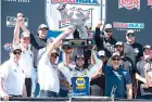  ?? AP Photo/jason Minto ?? Chase Elliott, center, holds up his trophy Monday after a NASCAR Cup Series auto race at Dover Motor Speedway in Dover, Del.